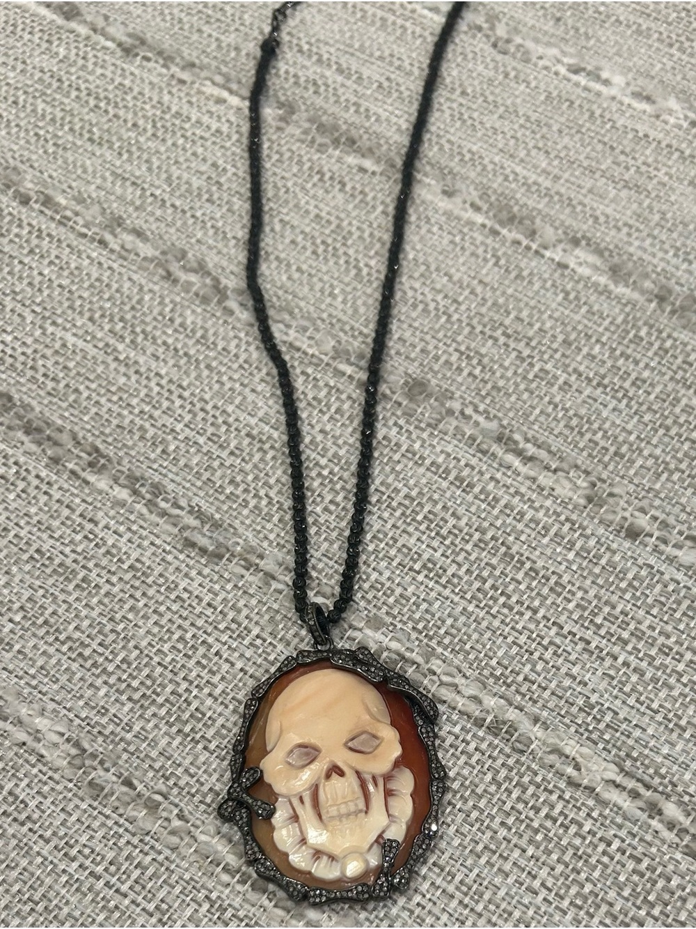 Gothic style necklace featuring carved skull cameo pendent with black chain
